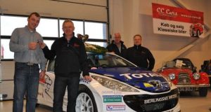 Esben Hegelund får overdraget nøgler til årets DM-vindervogn i rally af Danmarksmesteren Karl-Åge Jensen. Bag dem ses teamchef for Peugeot Sport Dealer Team DK Jens-Ole Kristiansen og årets sølvvinder Christian Jensen bag dennes vogn.