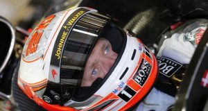 Kevin Magnussen sits in his car in the garage.