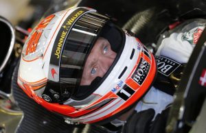 Kevin Magnussen sits in his car in the garage.